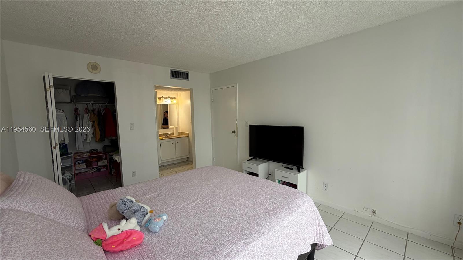 17011 North Bay Road, Unit 912 Sunny Isles Beach, FL 33160 - Photo 23 of 43 a bedroom with a bed and a flat screen tv