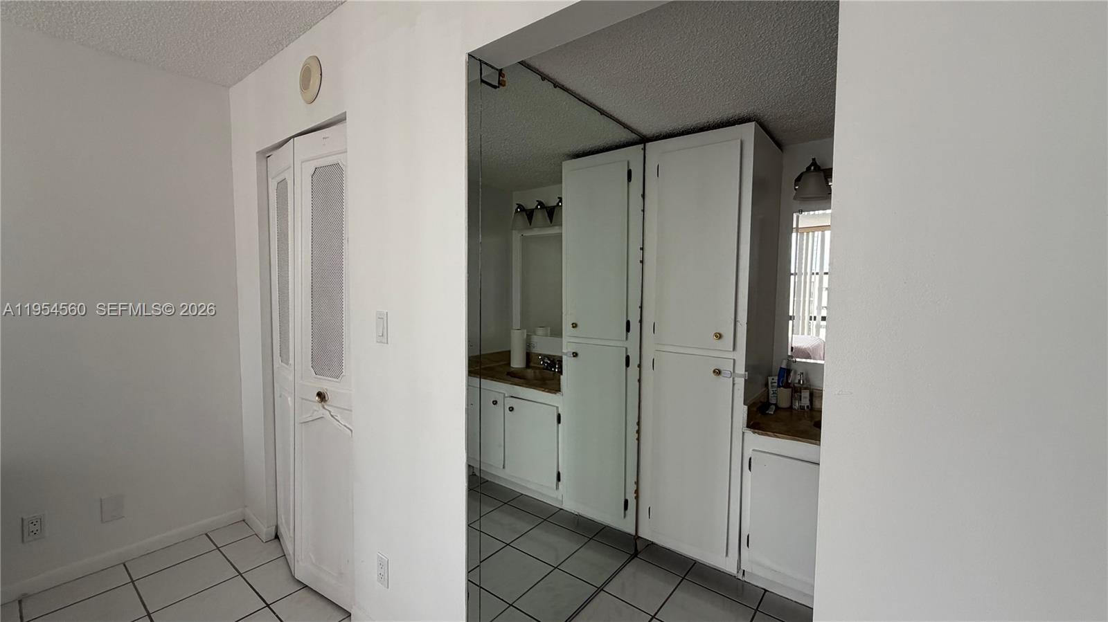 17011 North Bay Road, Unit 912 Sunny Isles Beach, FL 33160 - Photo 27 of 43 a bathroom with a granite countertop shower mirror and a sink
