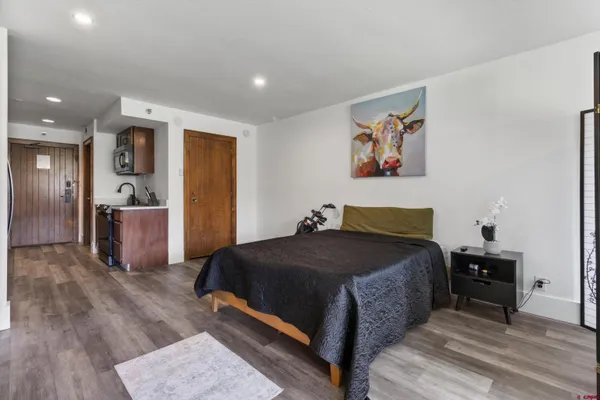a bedroom with a bed and a view of kitchen