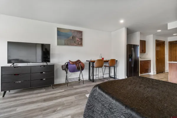 a spacious bedroom with a bed and a flat screen tv