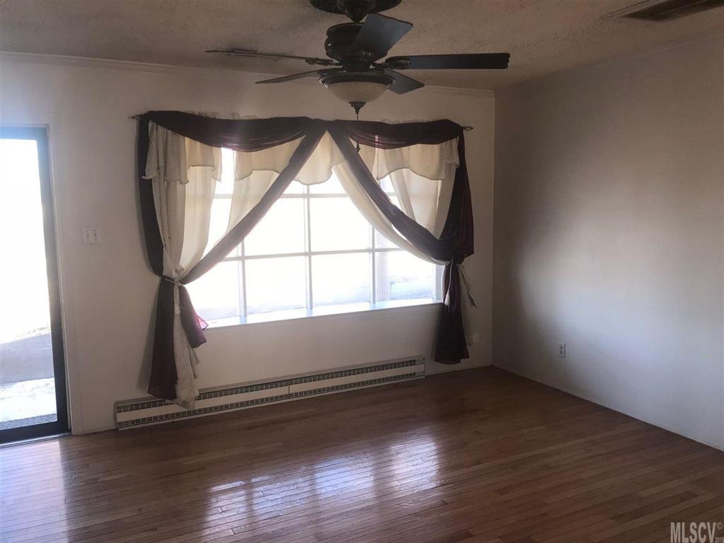 316 York Road Stony Point, NC 28678 - Photo 4 of 15 an empty room with wooden floor and windows