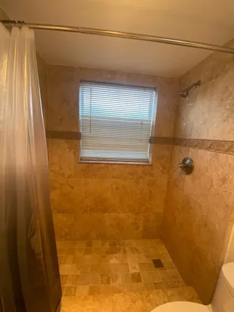 a bathroom with a granite countertop sink toilet and shower