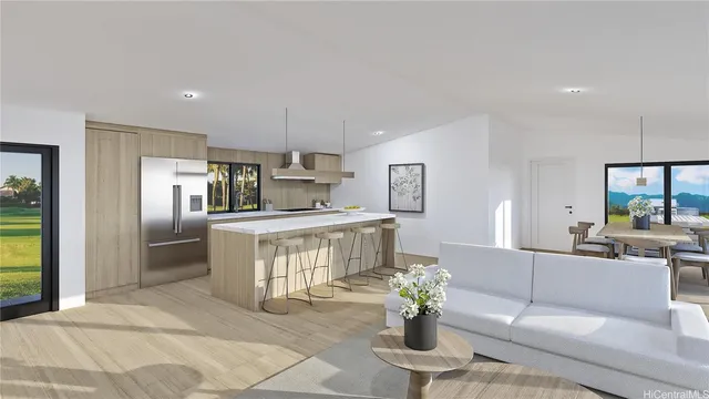 a living room with furniture a potted plant and kitchen view