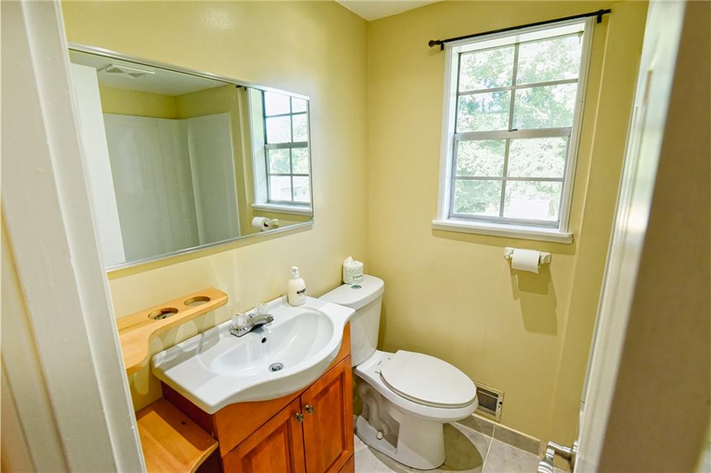6418 Maddox Road Morrow, GA 30260 - Photo 19 of 30 a bathroom with a sink a toilet and a mirror