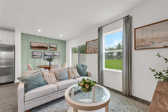 a living room with furniture and a view of kitchen