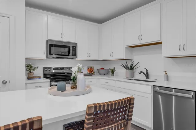 a kitchen with stainless steel appliances a stove a sink a microwave and cabinets