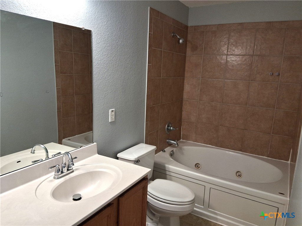 5605 Bald Ridge Court Killeen, TX 76542 - Photo 12 of 17 a bathroom with a bathtub shower sink vanity mirror and toilet