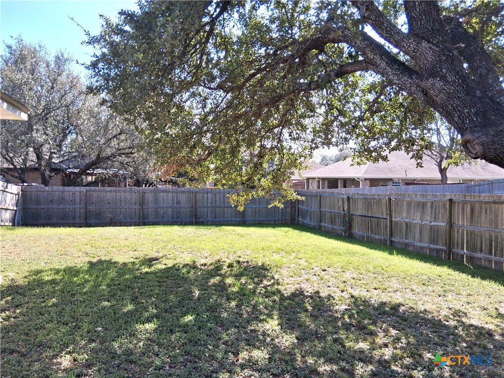 5605 Bald Ridge Court Killeen, TX 76542 - Photo 3 of 17 a view of a backyard with a large tree and wooden fence