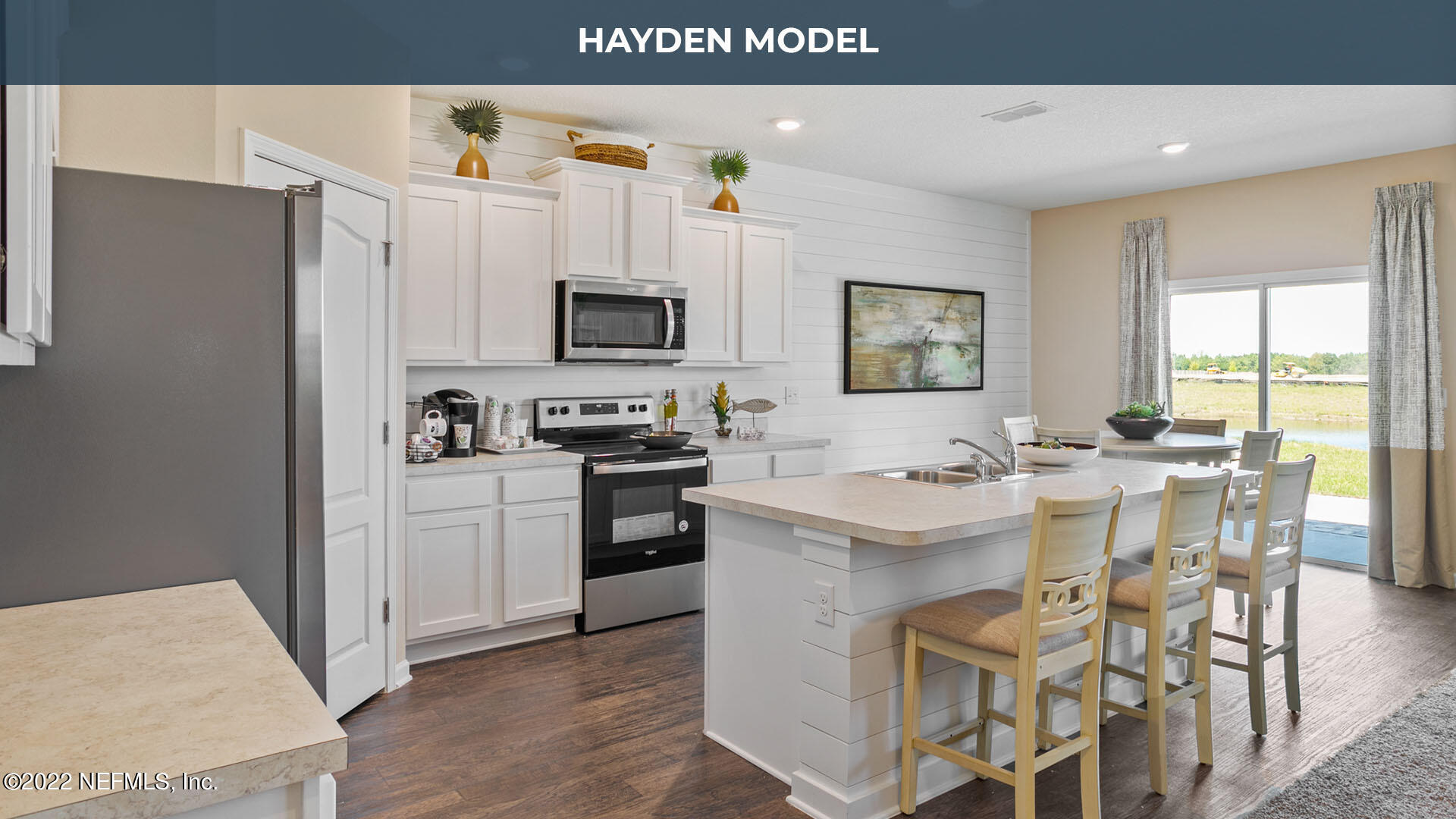 187 Encanto Way Street St. Augustine, FL 32084 - Photo 6 of 47 a kitchen with white cabinets and stainless steel appliances