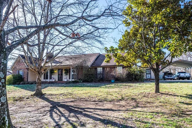 a view of a house with a yard and tree s