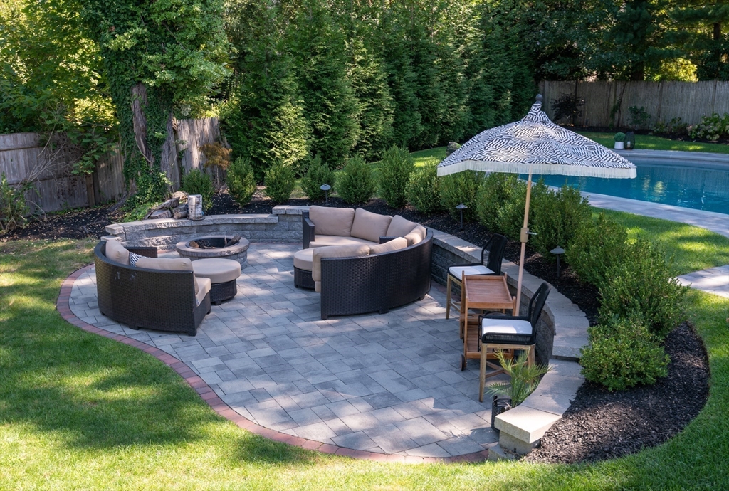 19 Longbow Road Lynnfield, MA 01940 - Photo 35 of 41 a view of a patio with table and chairs under an umbrella with a garden