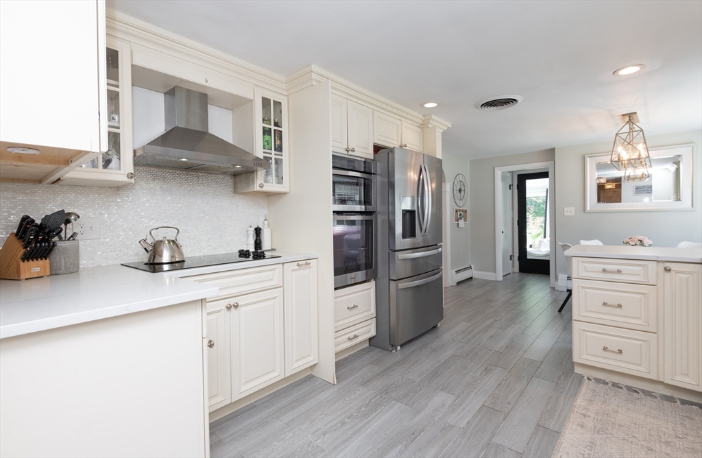 19 Longbow Road Lynnfield, MA 01940 - Photo 7 of 41 a kitchen with white cabinets and stainless steel appliances