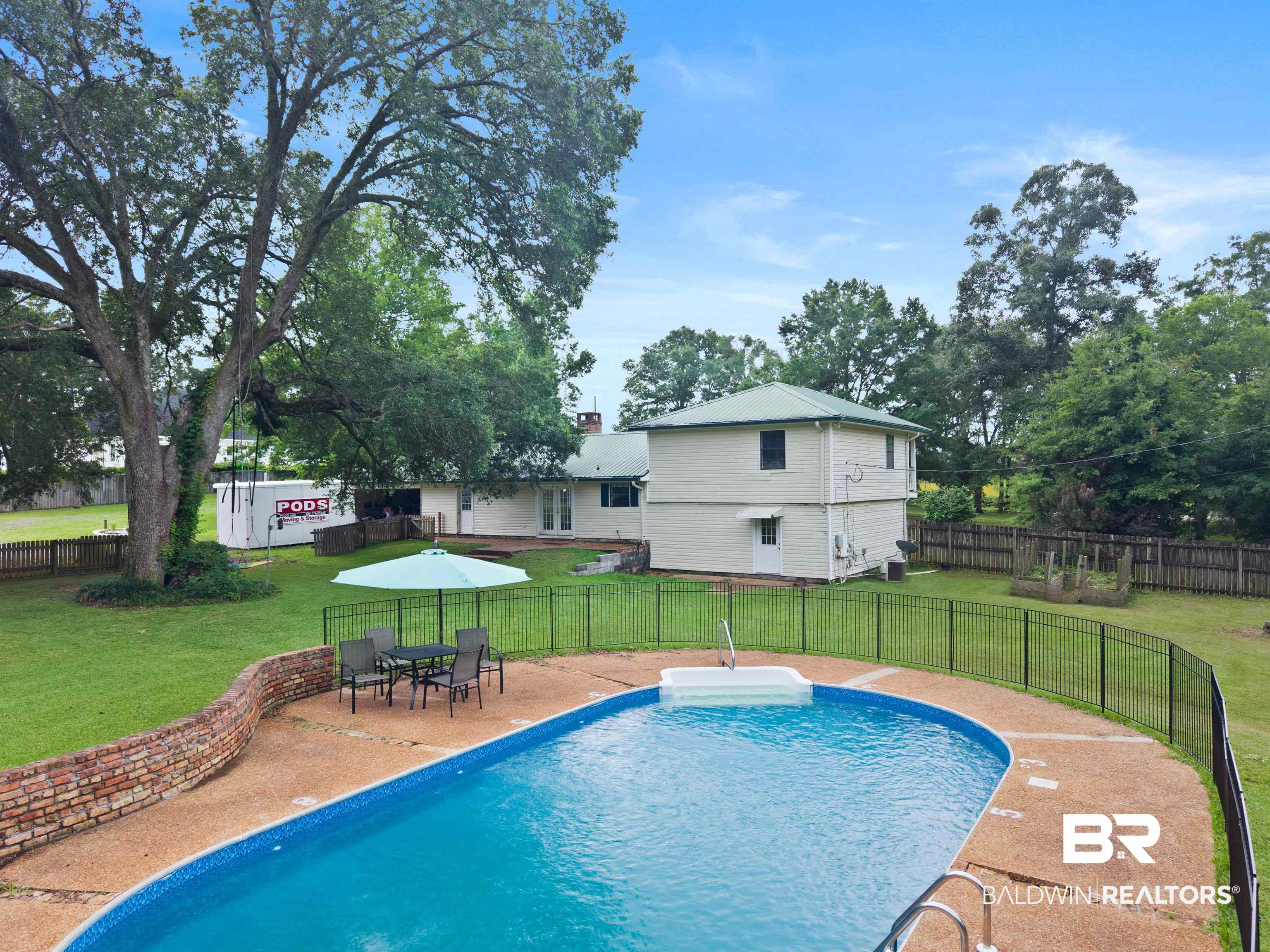 10420 Johnson Road South Mobile, AL 36695 - Photo 54 of 75 In-ground swimming pool with concrete surround, wrought iron fencing, and brick retaining wall
