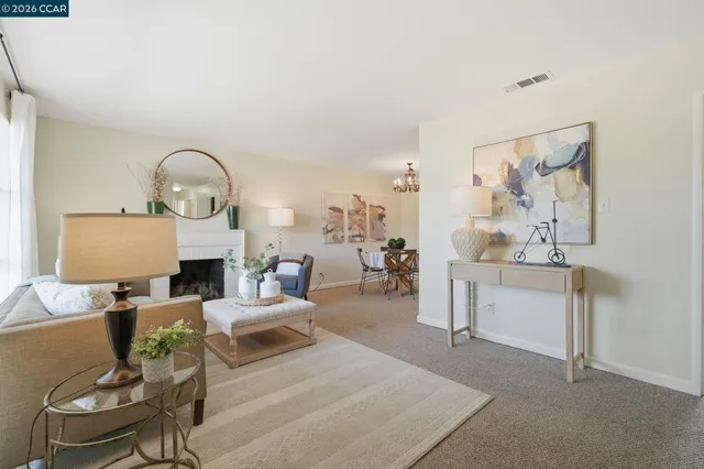 a living room with furniture a fireplace and a mirror