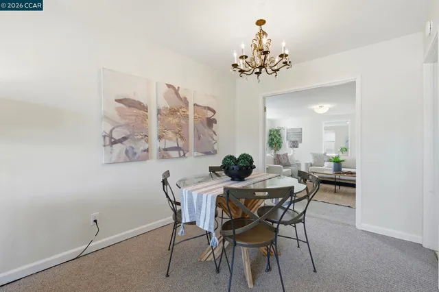 a view of a dining room with furniture and a chandelier