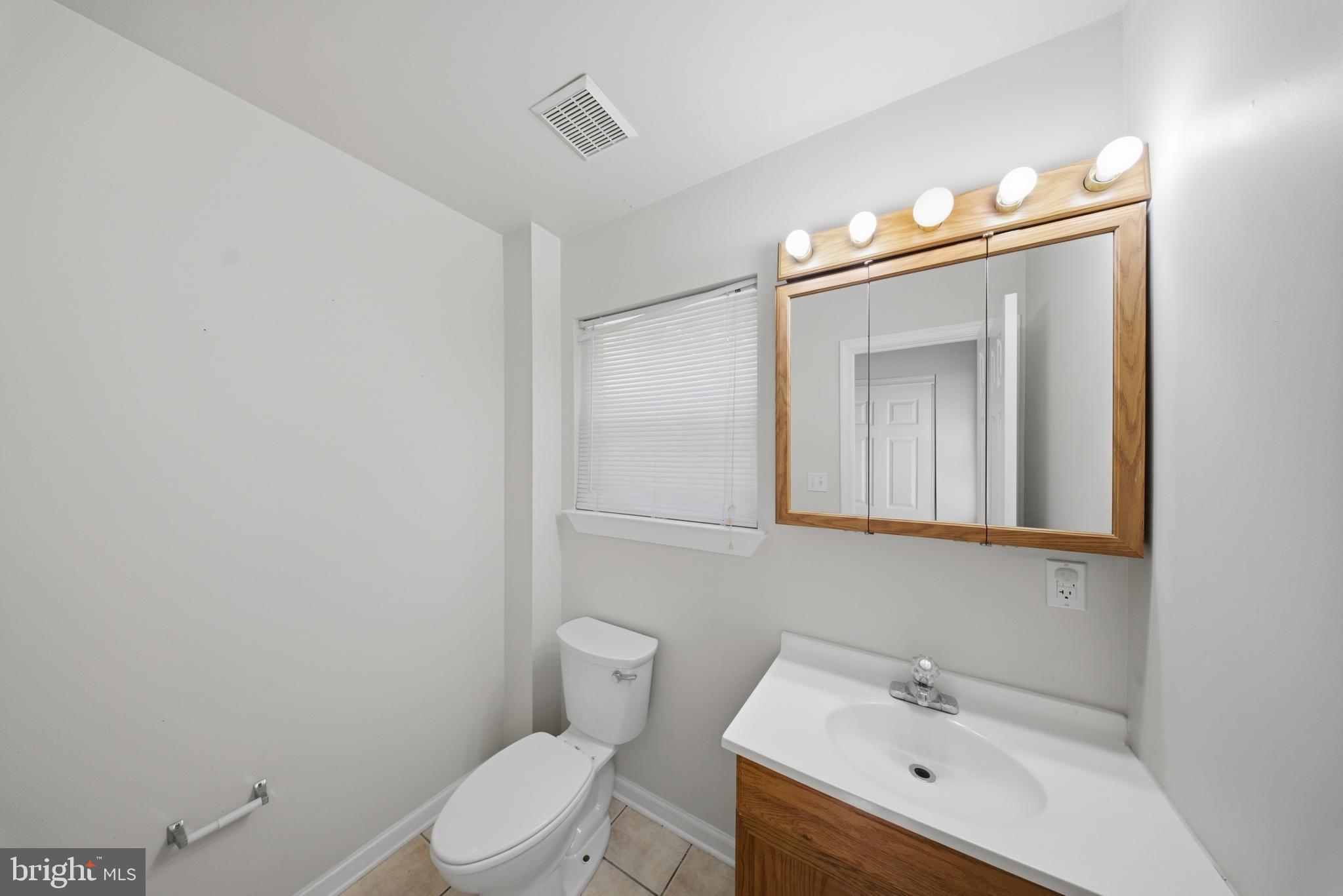 7611 Temple Hill Road Temple Hills, MD 20748 - Photo 7 of 25 a bathroom with a sink a toilet and mirror