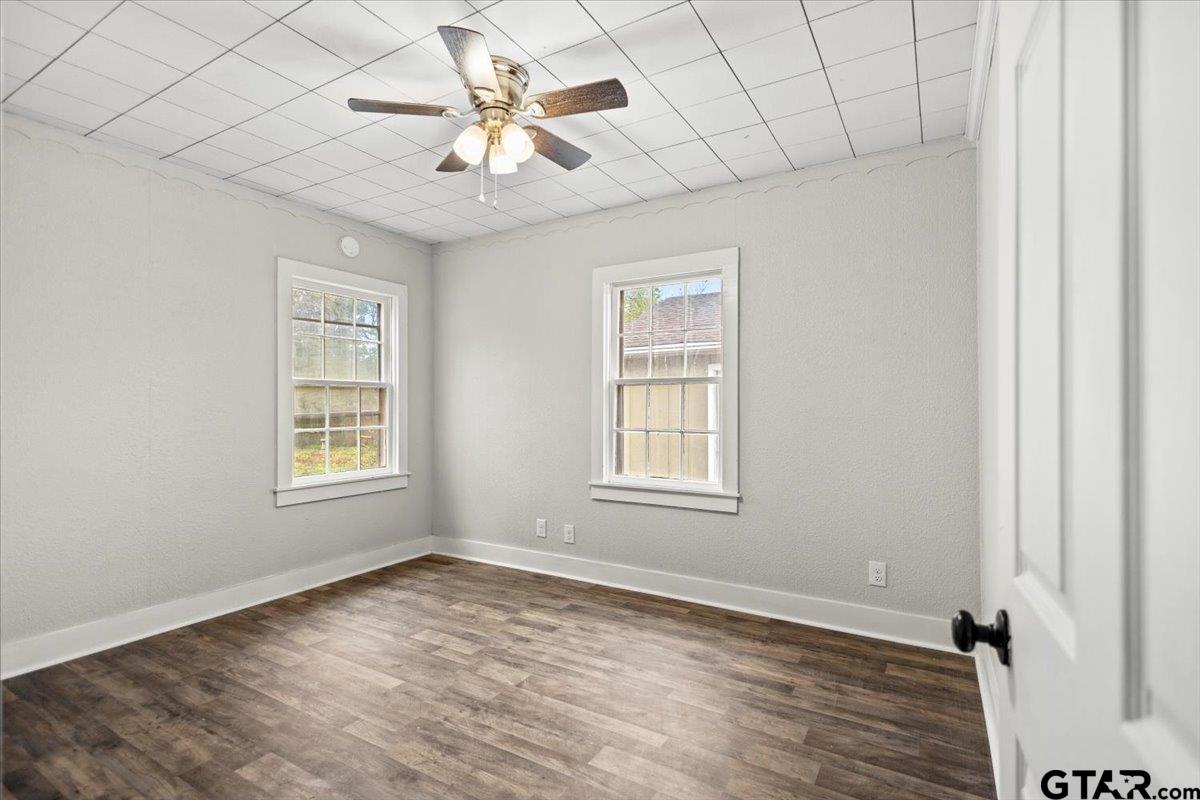 2707 Dudley Road Kilgore, TX 75662 - Photo 15 of 29 an empty room with a chandelier fan and windows