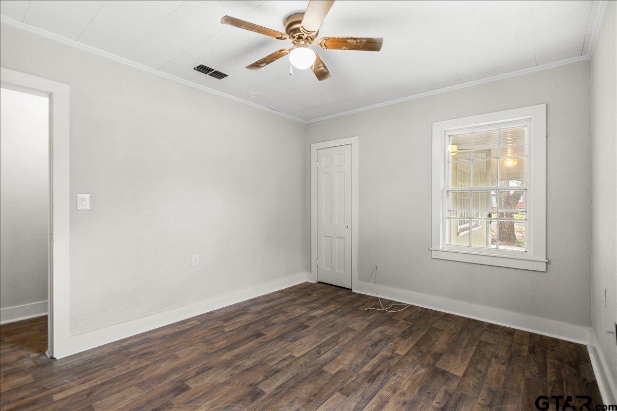 2707 Dudley Road Kilgore, TX 75662 - Photo 19 of 29 an empty room with wooden floor ceiling fan and windows