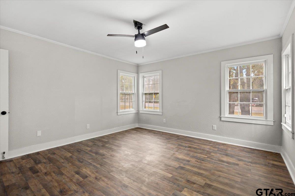 2707 Dudley Road Kilgore, TX 75662 - Photo 24 of 29 an empty room with wooden floor ceiling fan and windows