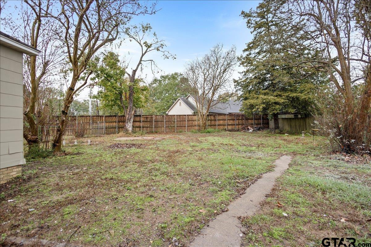 2707 Dudley Road Kilgore, TX 75662 - Photo 29 of 29 a backyard of a house with large trees and wooden fence