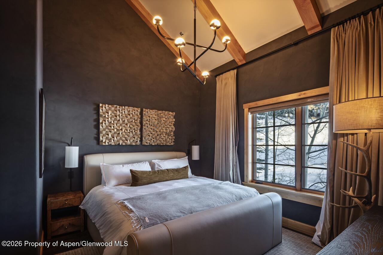 425 Wood Road, Unit 58F Snowmass Village, CO 81615 - Photo 16 of 32 a bedroom with a large bed and a window