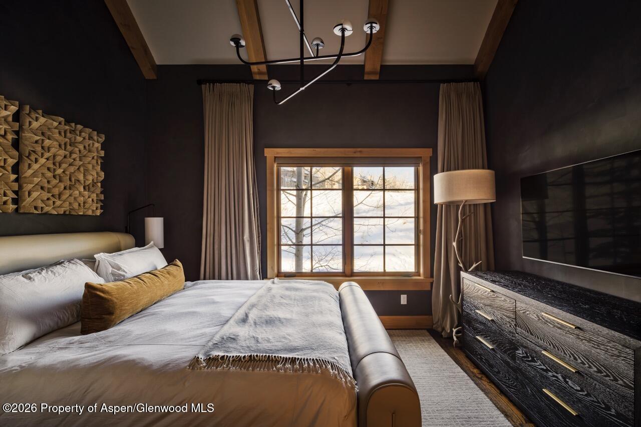 425 Wood Road, Unit 58F Snowmass Village, CO 81615 - Photo 17 of 32 a bedroom with a large bed and a window