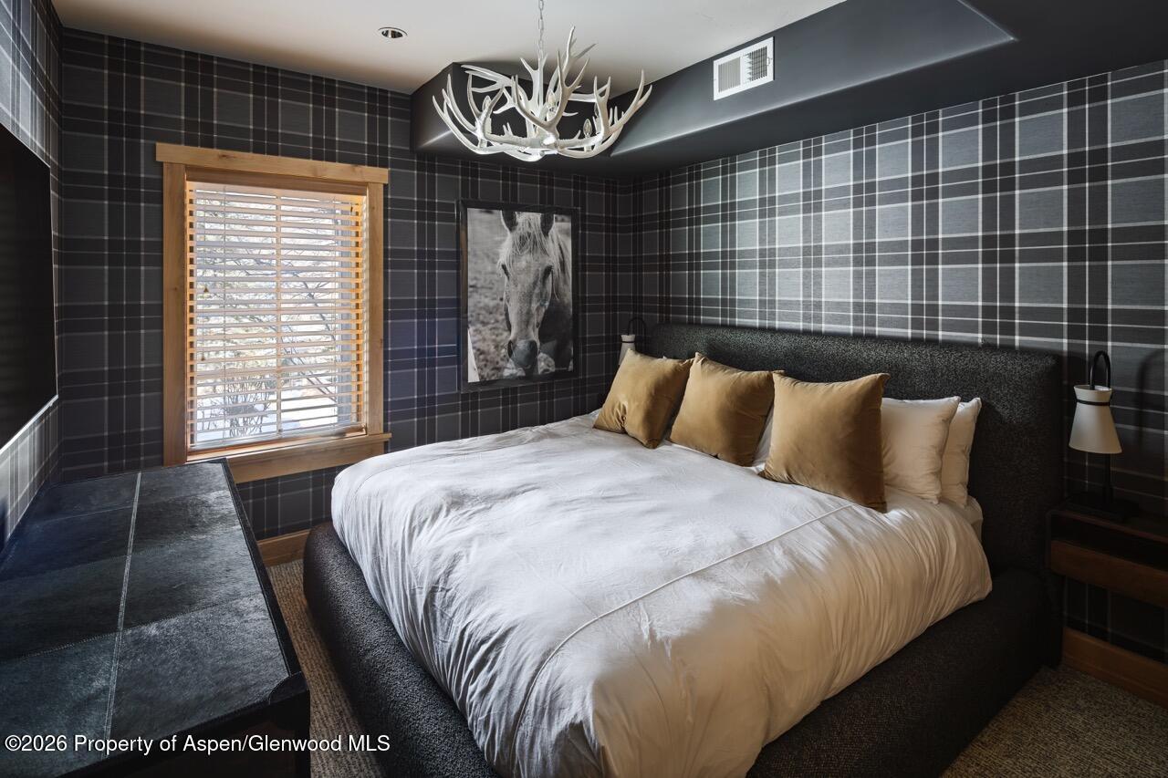 425 Wood Road, Unit 58F Snowmass Village, CO 81615 - Photo 19 of 32 a bedroom with a bed and wooden floor