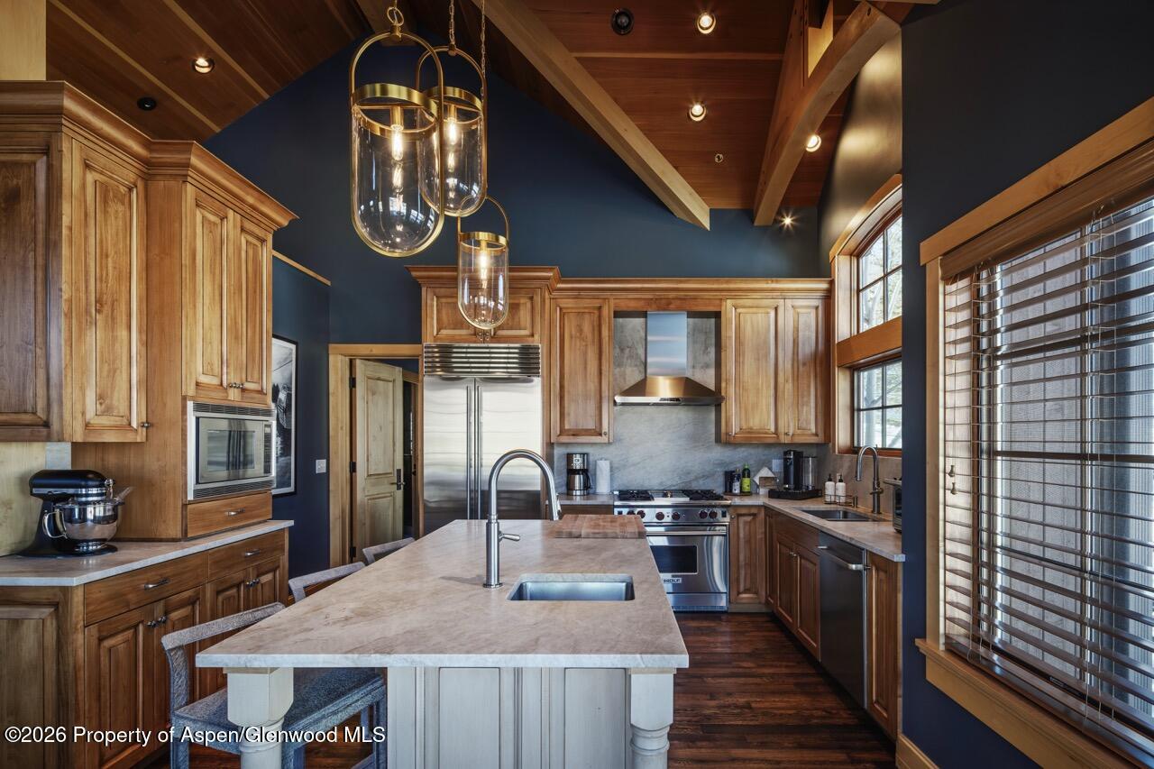 425 Wood Road, Unit 58F Snowmass Village, CO 81615 - Photo 8 of 32 a kitchen with stainless steel appliances granite countertop a sink a stove and a wooden cabinets