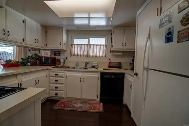 a kitchen with granite countertop a refrigerator stove and sink