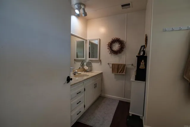 a bathroom with a granite countertop sink a mirror and shower view