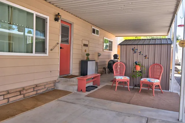 a backyard of a house with sofas and chairs