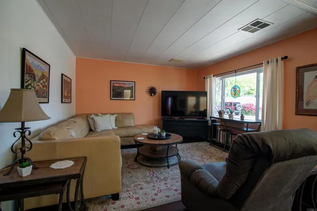 a living room with furniture a flat screen tv and a large window