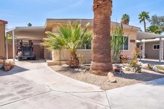 a view of a house with backyard and sitting area