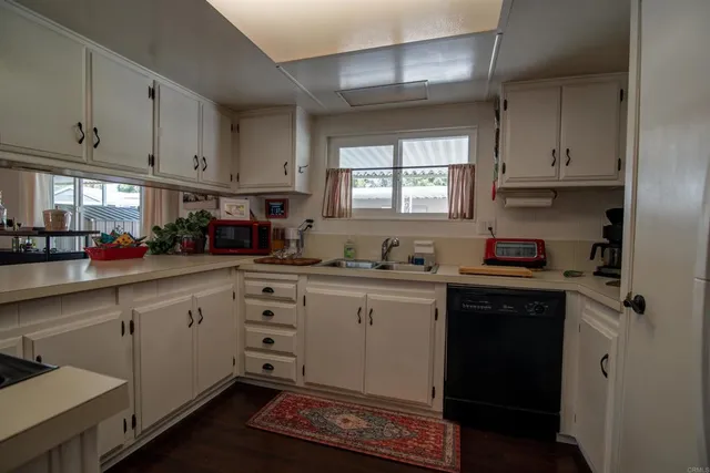 a kitchen with granite countertop white cabinets and white appliances