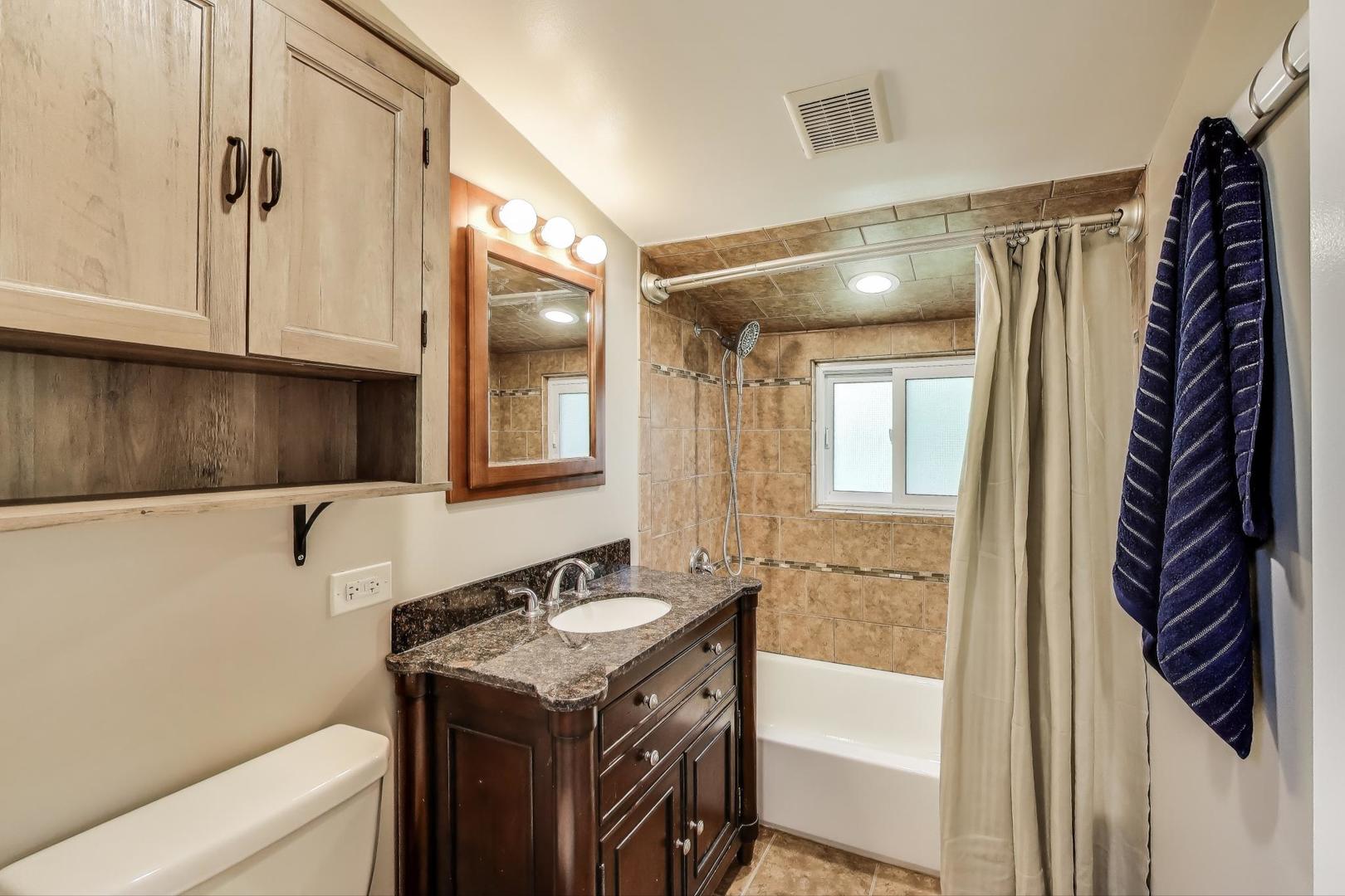 600 Long Road Glenview, IL 60025 - Photo 25 of 33 a bathroom with a sink a mirror and a bathtub