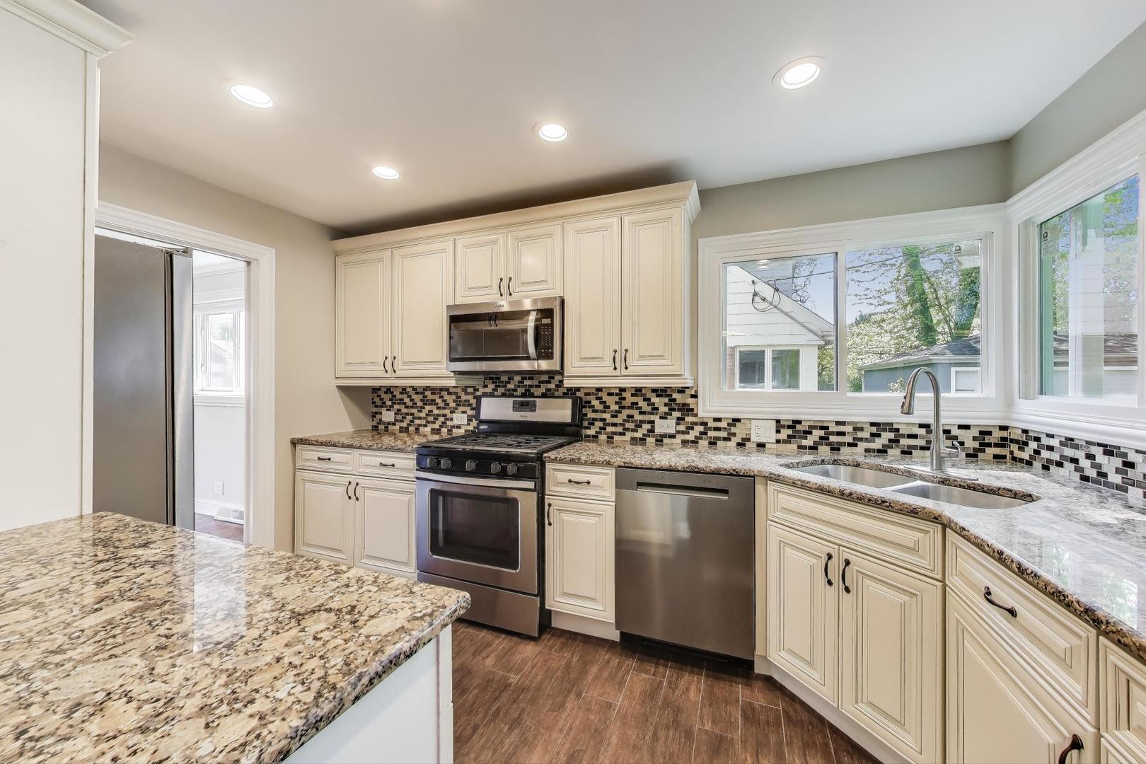 600 Long Road Glenview, IL 60025 - Photo 9 of 33 a kitchen with kitchen island granite countertop white cabinets and appliances