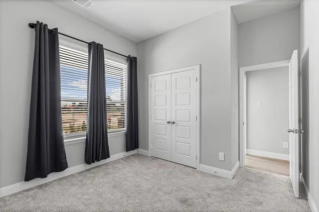 an empty room with windows and closet