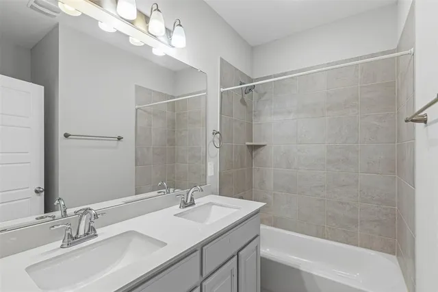 a bathroom with a sink double vanity mirror and a bathtub