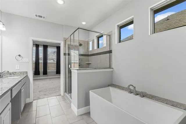 a bathroom with a granite countertop sink a mirror and bathtub