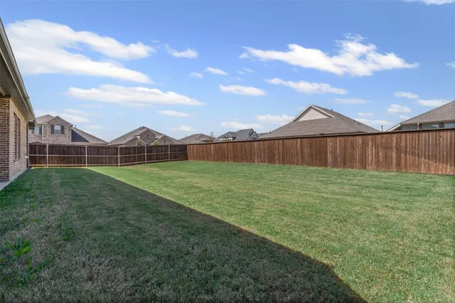 a view of a backyard with table and chairs and wooden fence