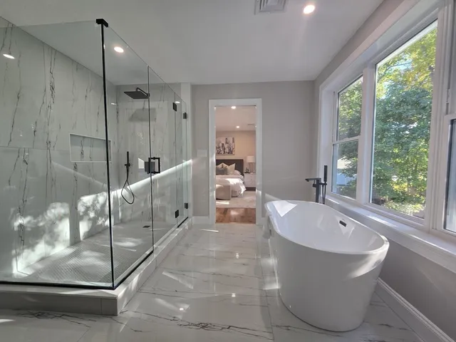 a large tub sitting next to a glass door shower