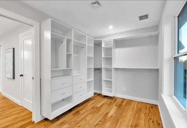 a view of an empty room with cabinet and a window
