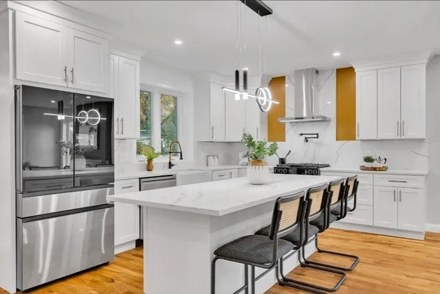 a kitchen with stainless steel appliances granite countertop a stove refrigerator sink and cabinets