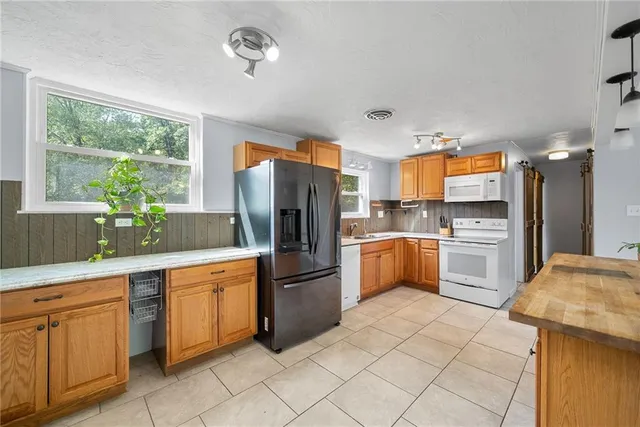 a kitchen with stainless steel appliances granite countertop a refrigerator and a sink