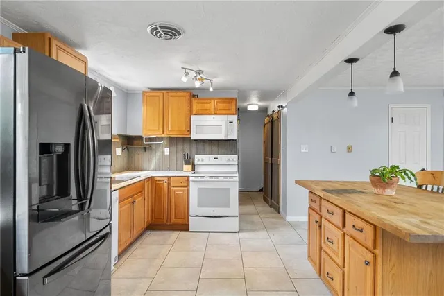 a kitchen with stainless steel appliances granite countertop a stove a sink a dining table and chairs