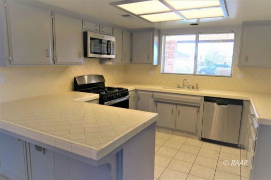 332 Larkspur Street Ridgecrest, CA 93555 - Photo 6 of 28 a kitchen that has a sink and a stove in it