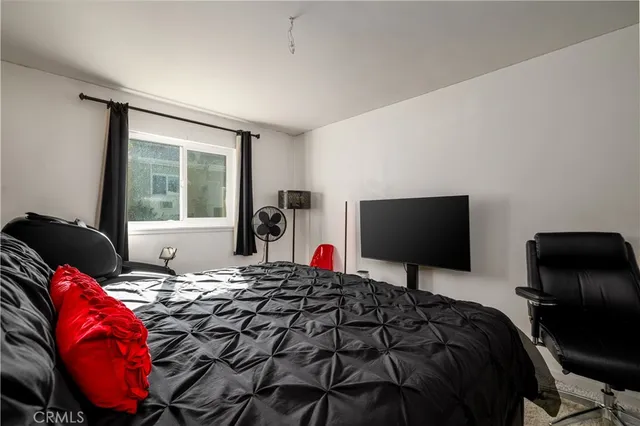 a bedroom with a bed and a flat screen tv