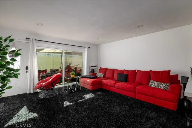 a living room with furniture with floor to ceiling window and potted plants