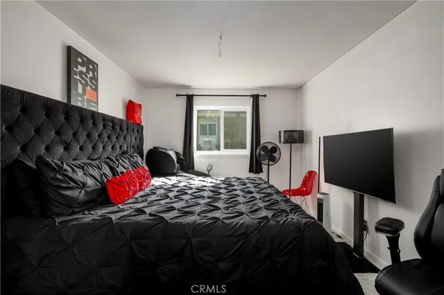 a bedroom with a bed and a flat screen tv