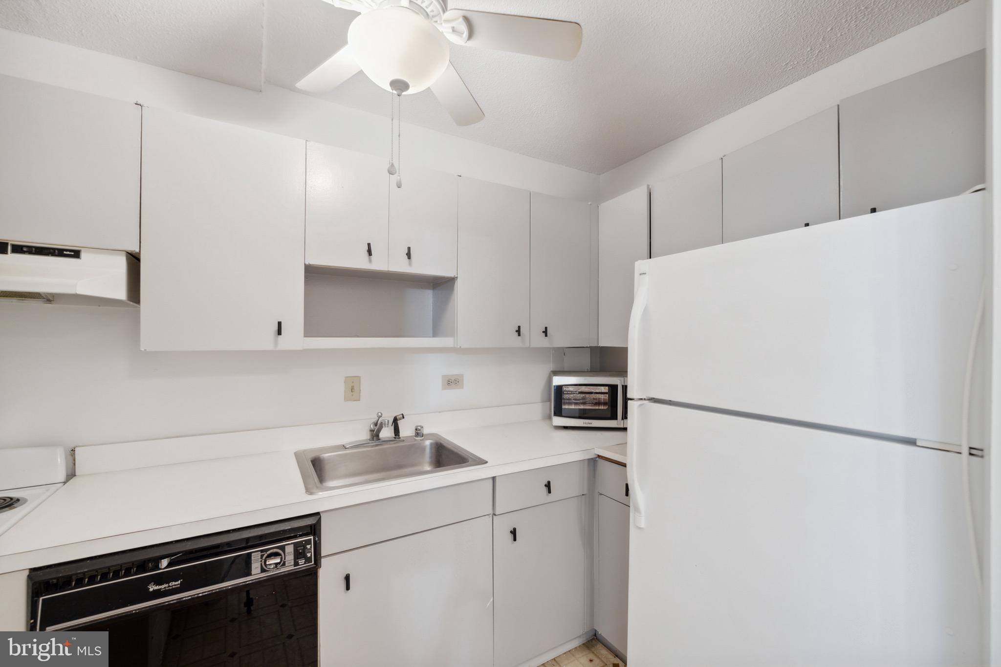 1301 Delaware Avenue Southwest, Unit N403 Washington, DC 20024 - Photo 7 of 14 a kitchen with a sink a refrigerator and white cabinets